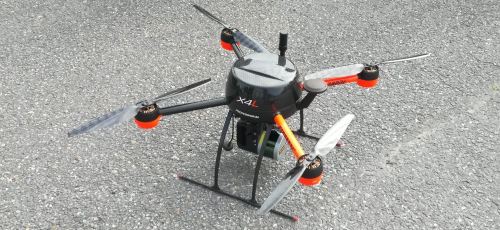 Lähikuva drone-laitteesta, joka on asfaltin päällä maassa.